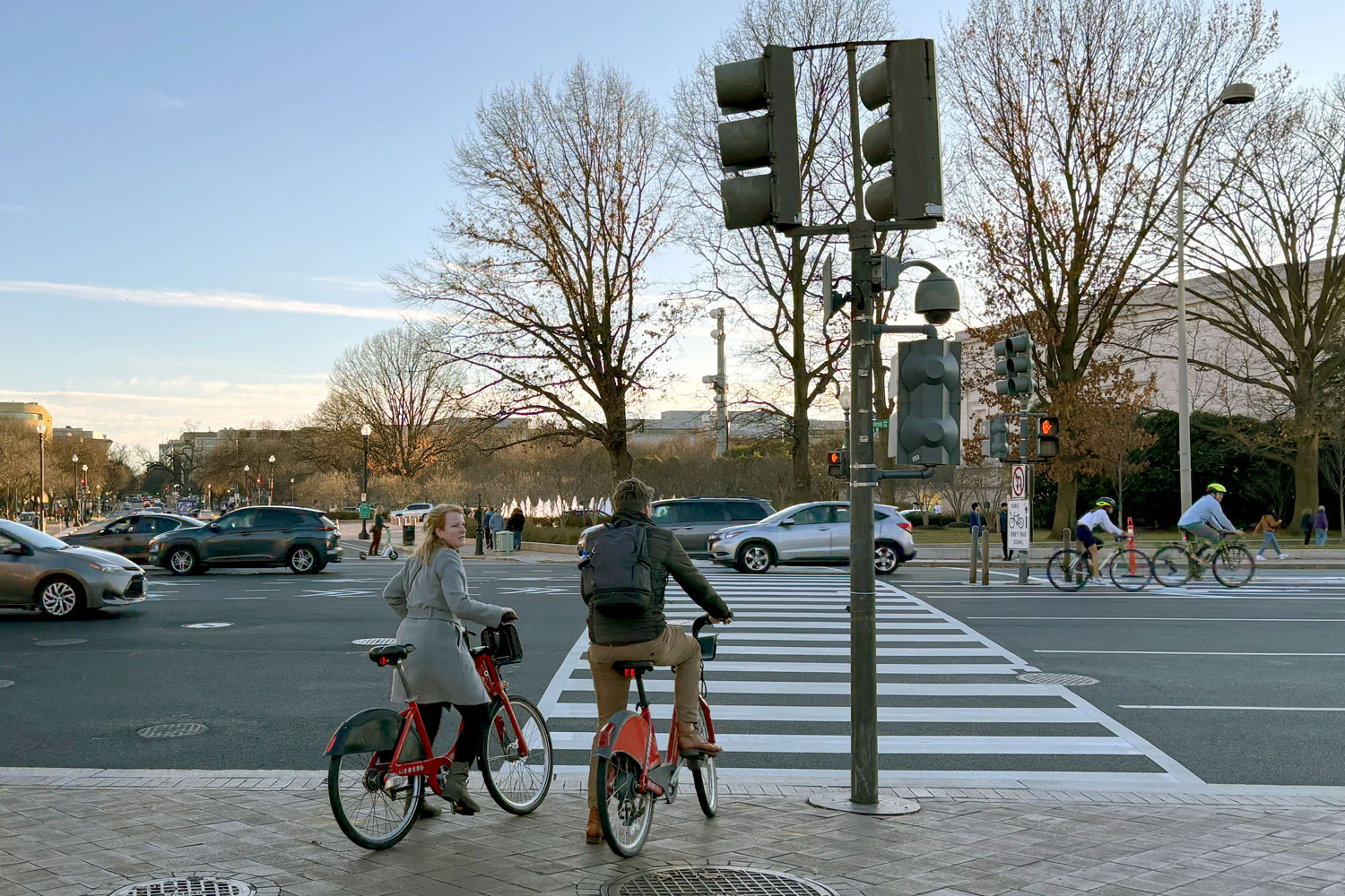 Bikeshare_Washington_DC_v3 Two people wait at a crosswalk with Capital Bikeshare bikes.